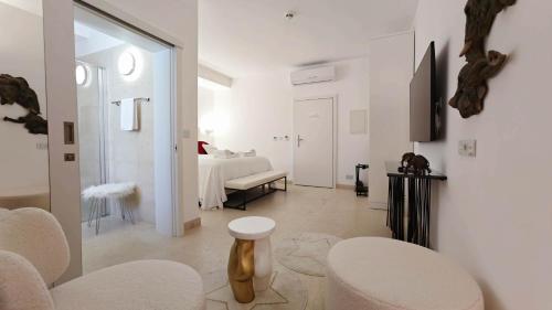 a white room with a bed and a table and chairs at The White Knight Premium Boutique Hotel in Għajnsielem