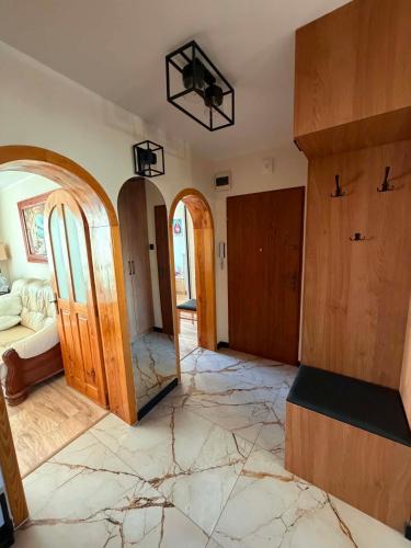 a living room with marble floors and a room with a bed at Apartament na Libelta in Wągrowiec