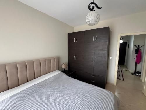 a bedroom with a large bed and a black cabinet at Gorenje apartment in Fier