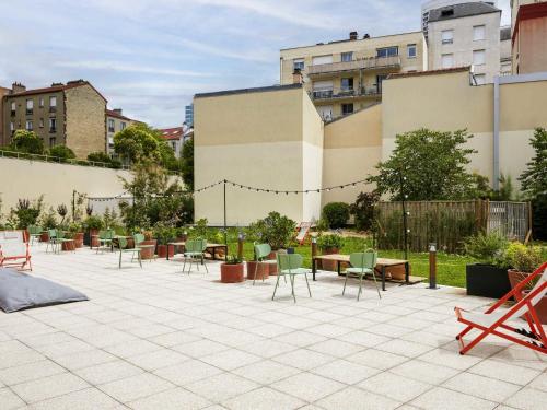 a patio with chairs and tables in a courtyard at Aparthotel Adagio Access La Défense Puteaux in Puteaux