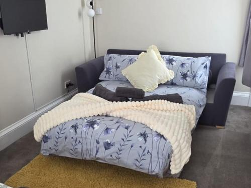 a blue couch with a blanket on top of it at Buckie Central 2 bed Retreat 24 high street in Buckie