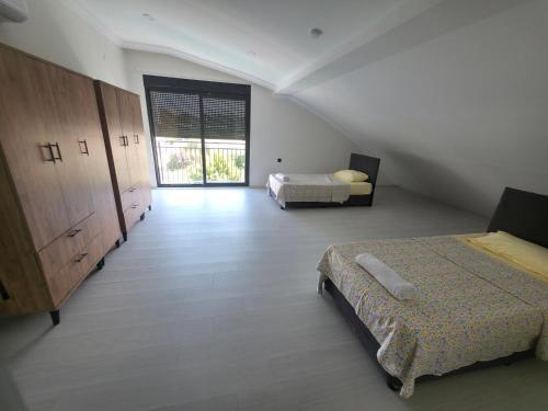 a bedroom with two beds and a large window at ViLLA ANGEL AHMET HASAN in Belek