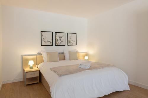 a bedroom with a large white bed with two lamps at Villa Anita in Chevreuse