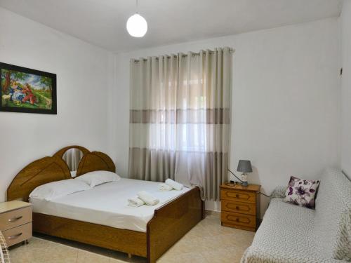 a small bedroom with a bed and a chair at Shtepi Manuel in Sarandë