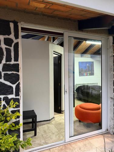 an open sliding glass door with an orange ottoman at Comodo Estudio 8 in El Gallinero
