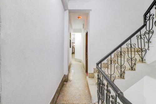 a hallway of a house with white walls and stairs at Super Hotel O by OYO Kavish Residency in Haridwār