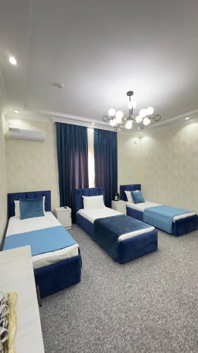 two beds in a room with blue beds in it at Hotel Imam Azam in Samarkand