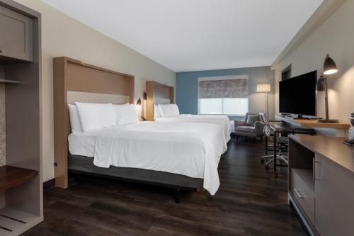a hotel room with a large bed and a flat screen tv at Holiday Inn - Tampa North by IHG in Tampa
