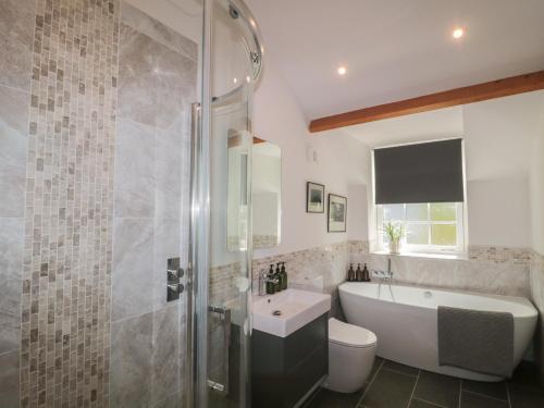 a bathroom with a tub and a toilet and a sink at The Little Vicarage in Highbridge