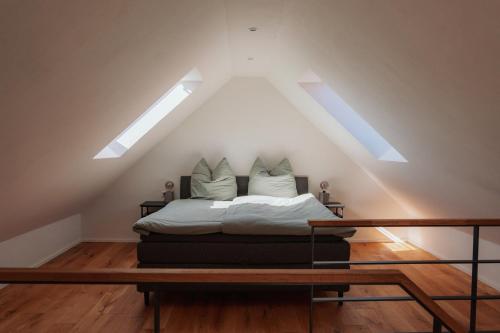 a bedroom with a bed under a roof with skylights at Ferienhaus am Dillbach in Hagen