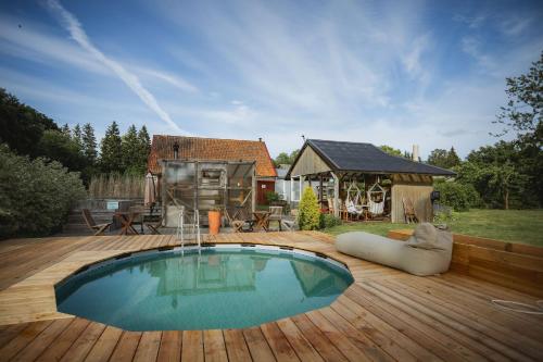 a swimming pool on a wooden deck with a house at Lakamajutus, telkimisala ja saunakompleks Pihtla Õlleköögis in Pihtla