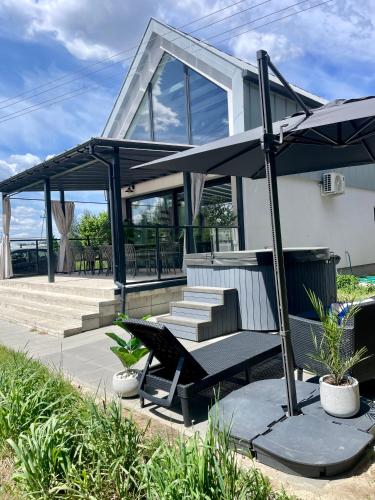 a house with a bench and an umbrella at Hampton Zalew Zegrzyński in Cupel