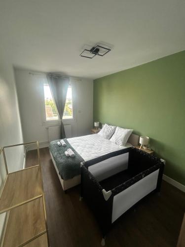 a bedroom with a bed in a green wall at Charmant T2 cosy au cœur de Caen Parking gratuit et arrivée autonome in Caen