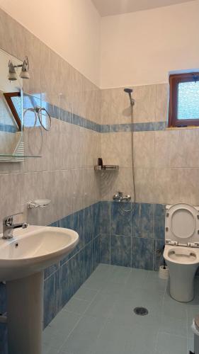 a bathroom with a sink and a toilet and a shower at White house 2 Ksamil in Sarandë