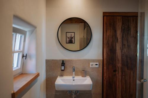 a bathroom with a sink and a mirror on the wall at Ferienhaus am Dillbach in Hagen