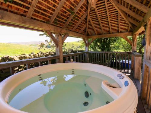 a hot tub on the deck of a house at Bib Knowl Farm in Littleborough