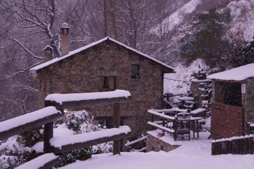 a log cabin in the snow with a fence at Masia Can Constans in Queralbs
