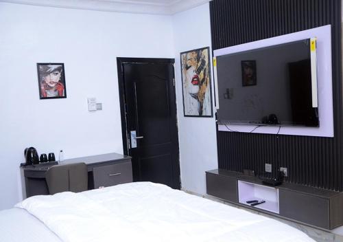 a bedroom with a bed and a flat screen tv at Lodgeselect in Ibadan