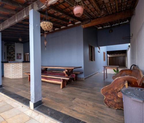 a large room with a table and benches in it at Casa com Piscina Aquecida e Churras em Uberlândia in Uberlândia