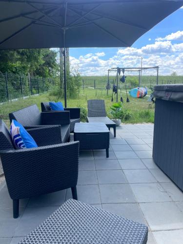 a patio with chairs and an umbrella and a playground at Hampton Zalew Zegrzyński in Cupel