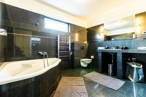 a large bathroom with a tub and a toilet at Guesthouse Tuta in Pakoštane