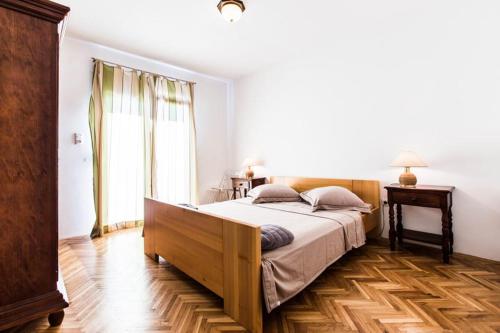 a bedroom with a large bed and a wooden floor at Guesthouse Tuta in Pakoštane