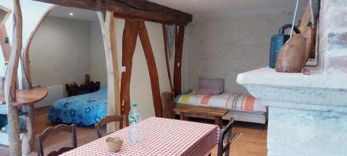 a room with a table and a bed in it at Gîte des petits givrés in Entrains-sur-Nohain