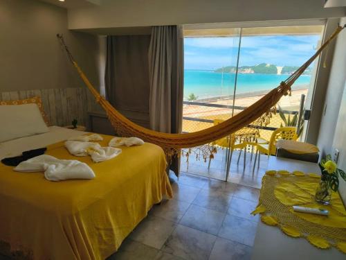 a bedroom with a hammock and a view of the beach at CosteiraPRAIASOLPontaNegra, Natal-RN in Natal