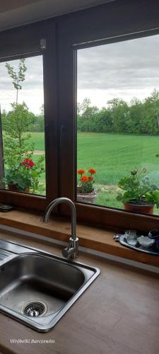 a kitchen sink and a window with a view of a field at Chata pod kogutem in Barczewko