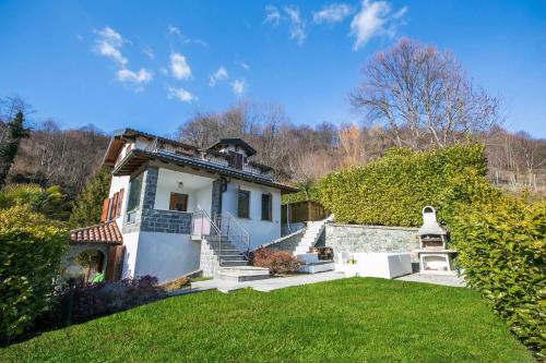 a house with a yard with grass and stairs at Casa dei Galli in Gravedona