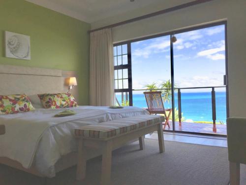 a bedroom with a bed and a view of the ocean at Classical View Guesthouse in Mossel Bay