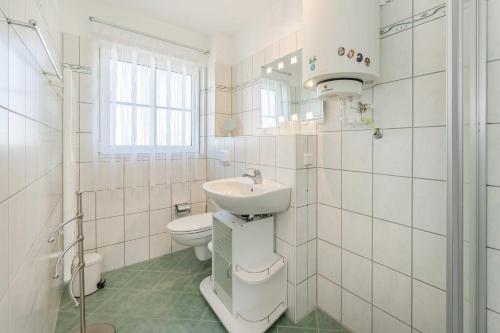 a white bathroom with a sink and a toilet at Ferienwohnung Strandliebe in Koserow