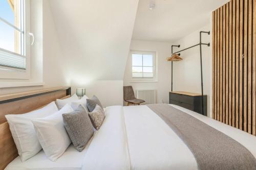 a bedroom with a large white bed with pillows at Ferienwohnung Strandliebe in Koserow