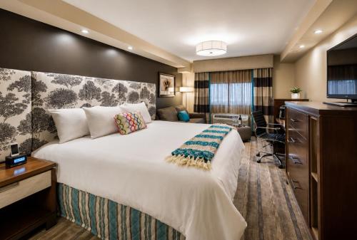 a hotel room with a large bed and a desk at The Kenilworth Hotel - Airport West in Kenilworth