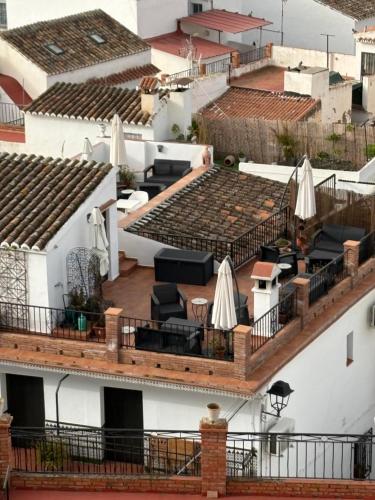 a view of the roofs of buildings with umbrellas at La Vieja Botica in Canillas de Aceituno