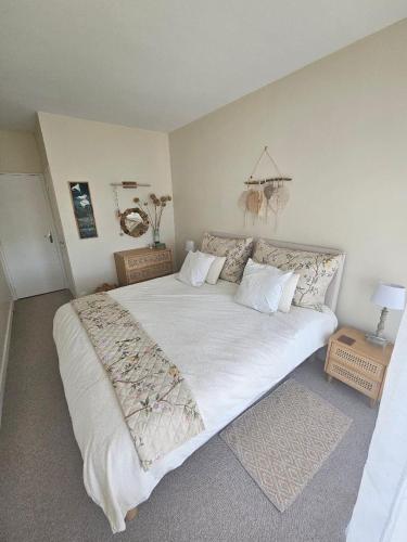 a bedroom with a large bed with white sheets at Jasmin Doux in Poitiers