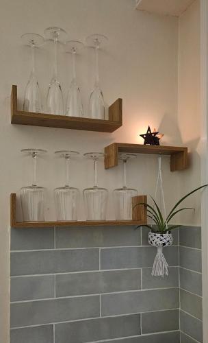 a bathroom with shelves with glasses on the wall at Jasmin Doux in Poitiers