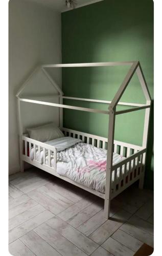 a white bunk bed in a room with a green wall at La coconing in Vierzon