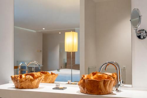 a bathroom sink with two faucets and a mirror at Arantza Hotela - Boutique Hotel "Adults Only" in Arantza