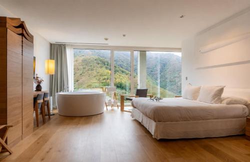 a bedroom with a bed and a tub and a window at Arantza Hotela - Boutique Hotel "Adults Only" in Arantza