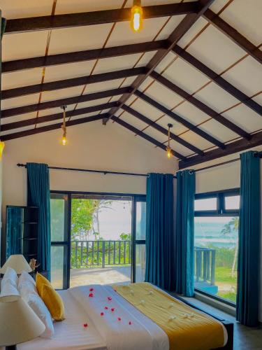 a bedroom with a large bed and a large window at Turtle Breeze Rekawa in Tangalle