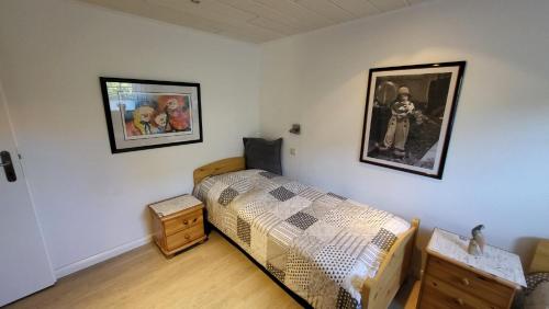 a bedroom with a bed and two pictures on the wall at Ferienwohnung Inge EG in Greetsiel