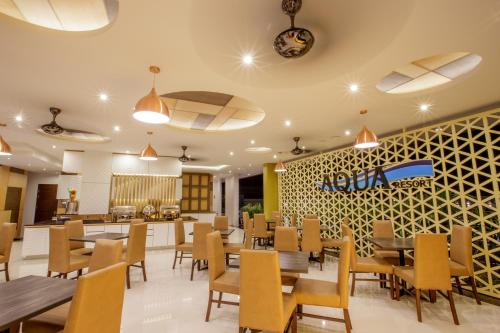 ein Esszimmer mit Tischen und Stühlen sowie ein Restaurant in der Unterkunft Aqua Resort SHA Plus in Rawai Beach