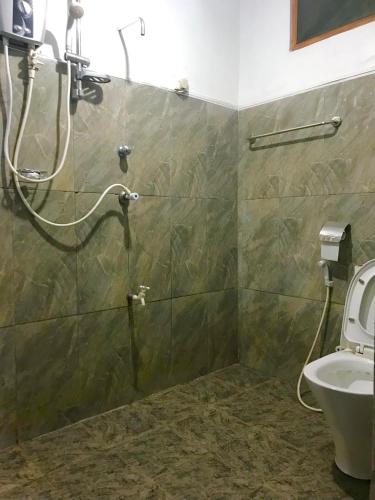 a bathroom with a shower with a sink and a toilet at Linwood Bungalow in Kandy