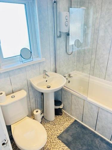 a bathroom with a toilet and a sink and a tub at Contractors , holiday house, free parking , sleeps 5 in Knowsley