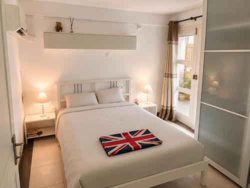 a bedroom with a bed with a british flag pillow on it at Casa Mangrove in Maputo