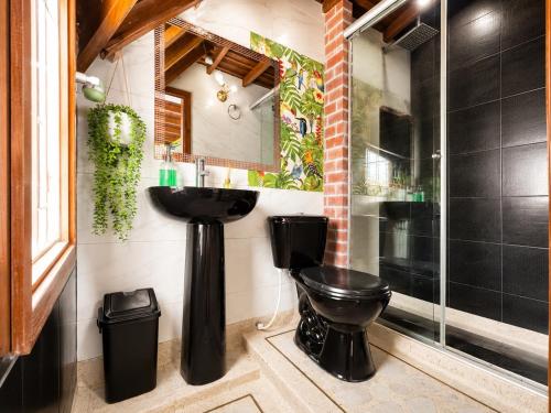 a bathroom with a black toilet and a sink at Tikki Lua in Cota