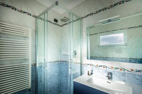ein Badezimmer mit Waschbecken und Glasdusche in der Unterkunft Hotel Stella in Rapallo