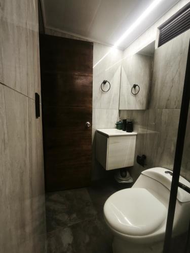 łazienka z białą toaletą i umywalką w obiekcie Casa Nuko w mieście Puracé