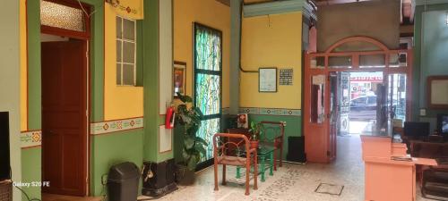 a room with green and yellow walls with a table and chairs at Hotel Republica in Mexico City
